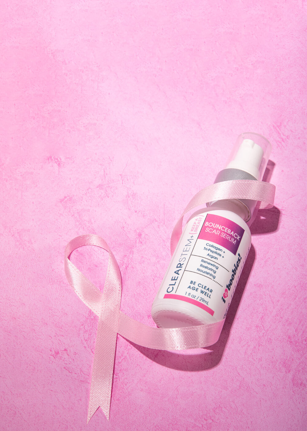a pink ribbon wrapped around a bottle of clearstem bounceback scar serum 